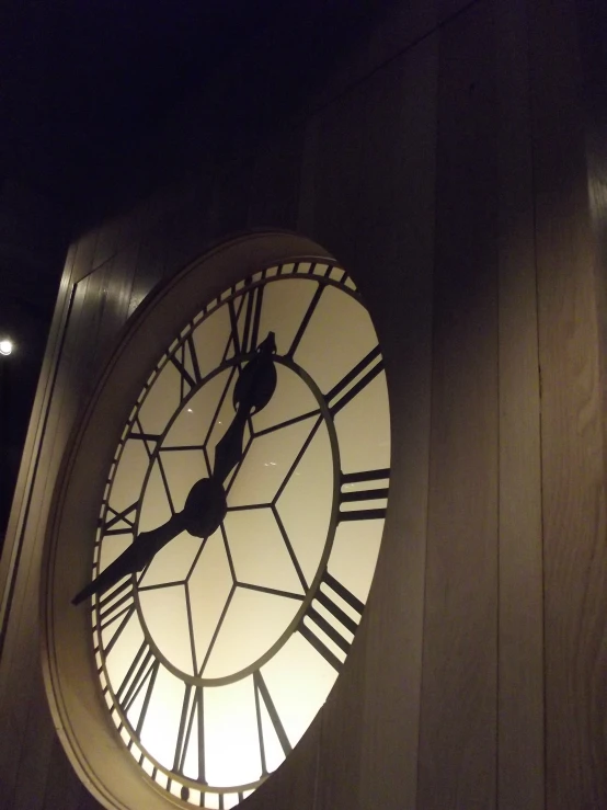 a clock with the face made of wood with white light