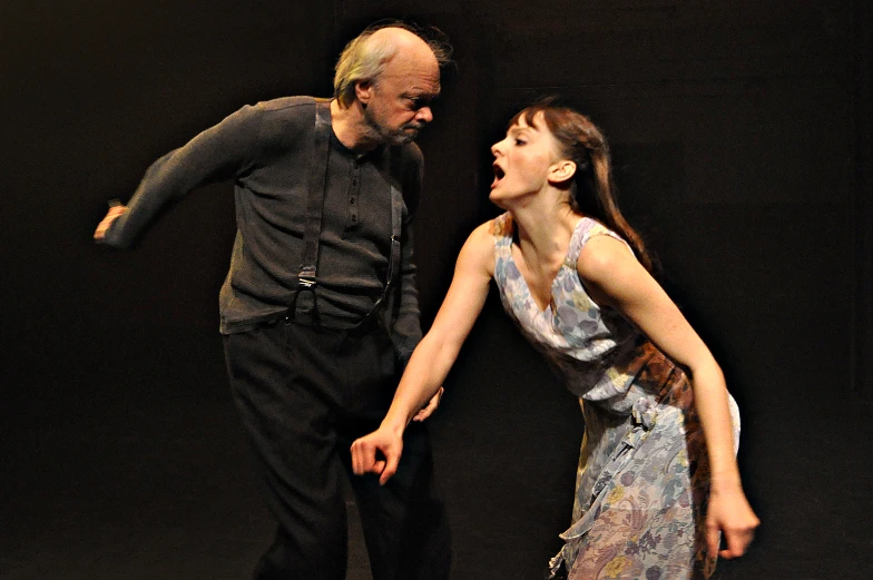 an older man and woman in costume on stage