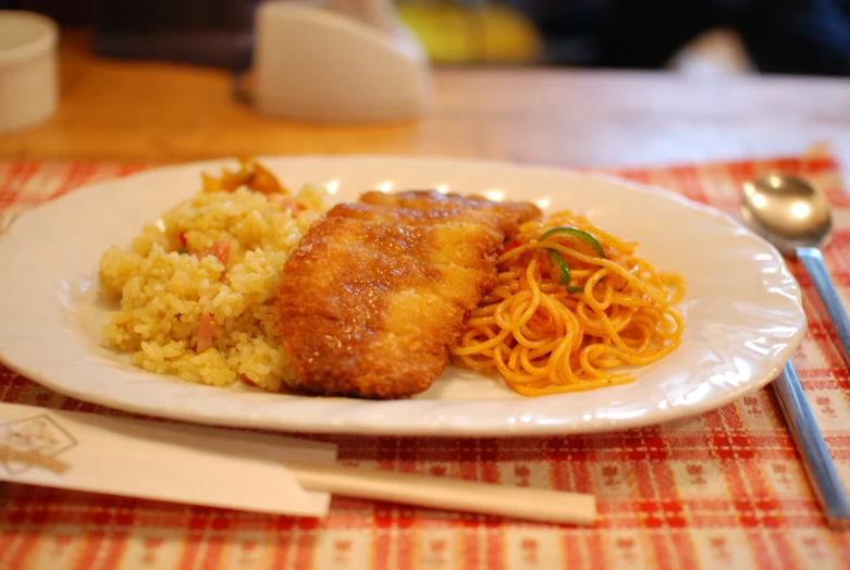 a plate topped with meat, rice and other foods