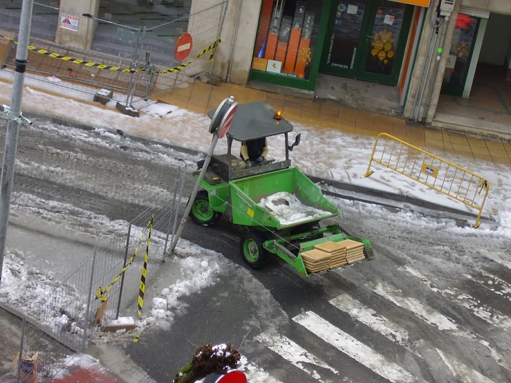 an automated green vehicle with a person looking at soing