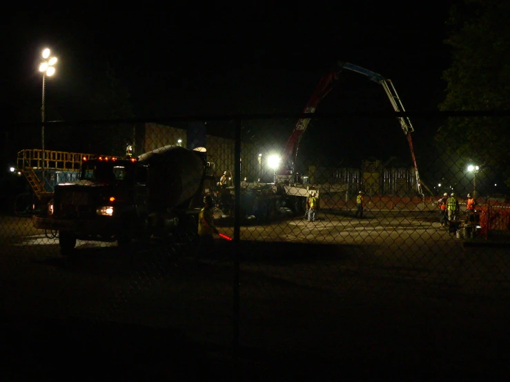 a large crane is in the dark with its lights on