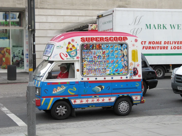 a small colorful truck drives down a city street