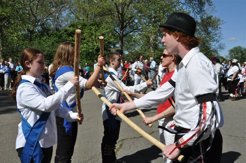 several people holding stick during a parade