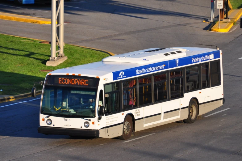 a white bus driving down the street