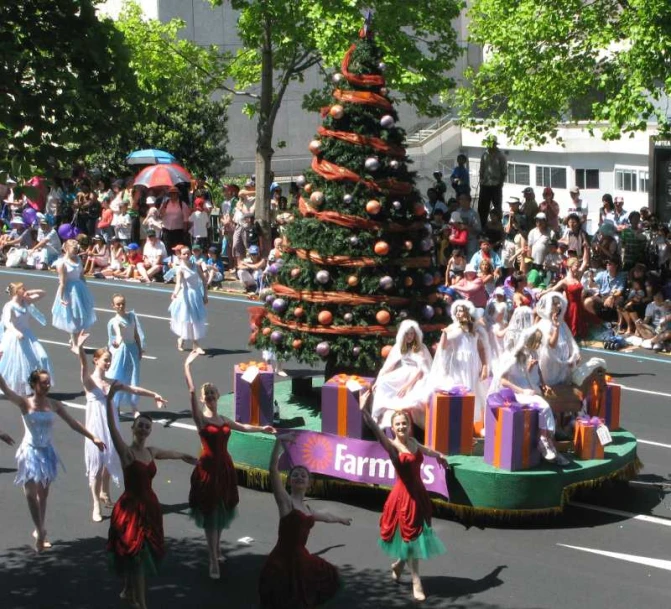 a group of people on a street next to a christmas tree