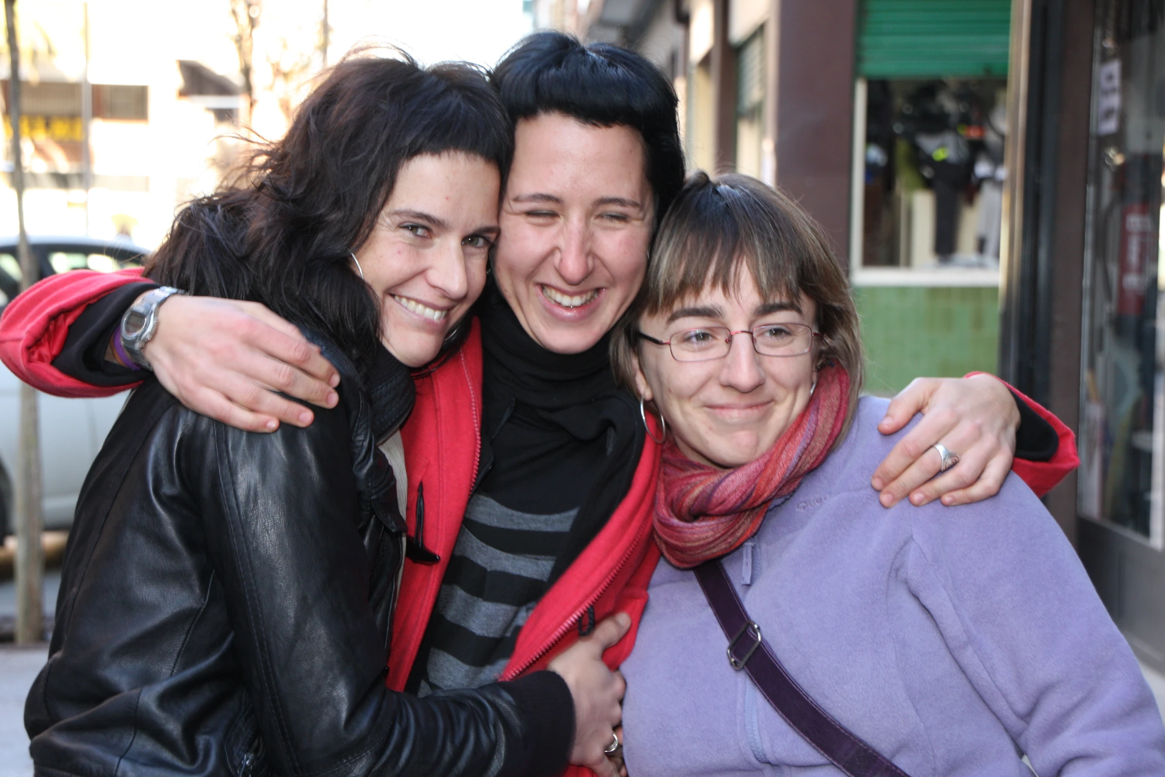 three women standing in front of a store