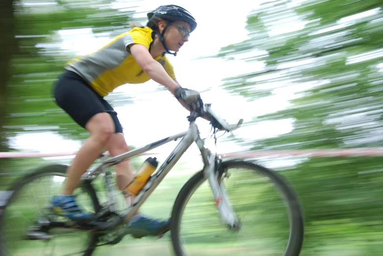 a woman is riding her mountain bike through the trees