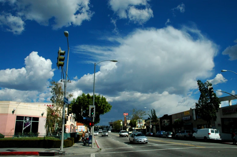 cars and trucks are on the street under a cloudy sky