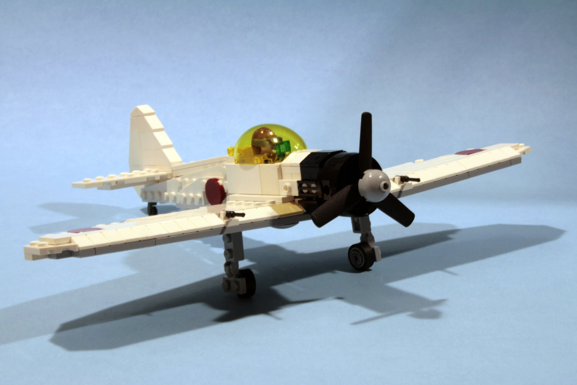 a white lego airplane sitting on top of a blue table