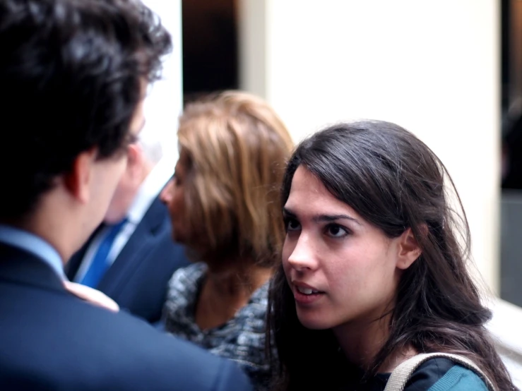 a woman is in a crowd talking to one another