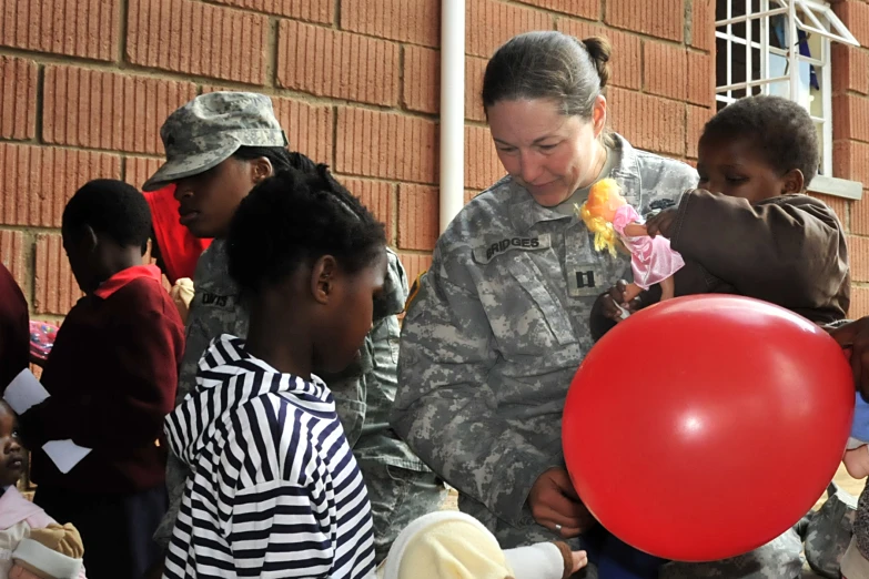 the woman is handing flowers to a child