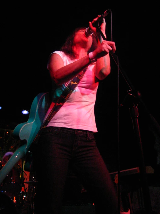 a man playing guitar at night on stage