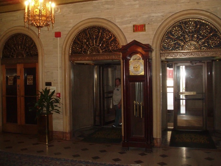 a room with columns, large clock, and an open door