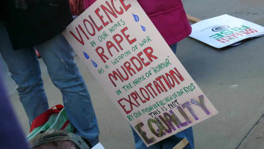 someone holding a sign that says violence, race murder, expulimation