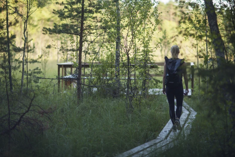 woman walking on a path with backpack in the forest