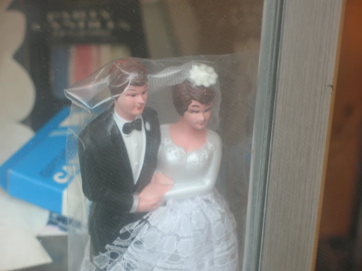 a plastic wedding cake topper, a bride and groom, in the box