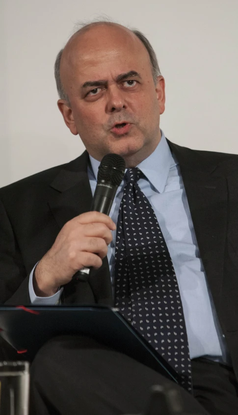 a man in a suit is talking into a microphone