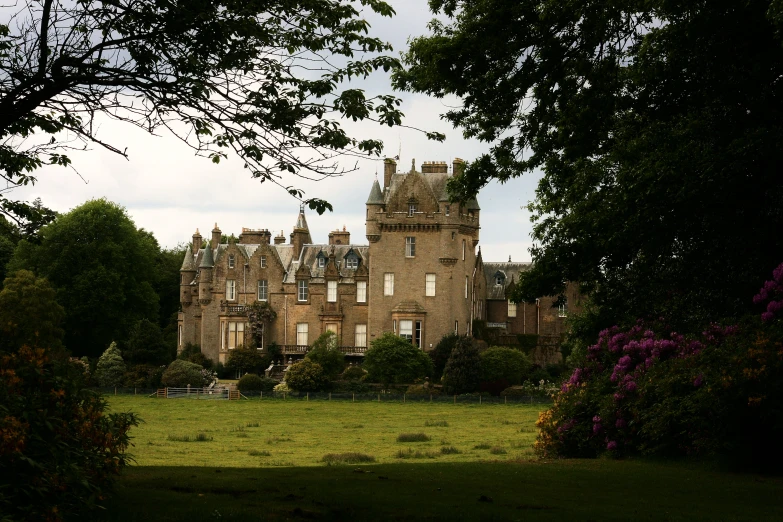 an old castle with a grassy park below