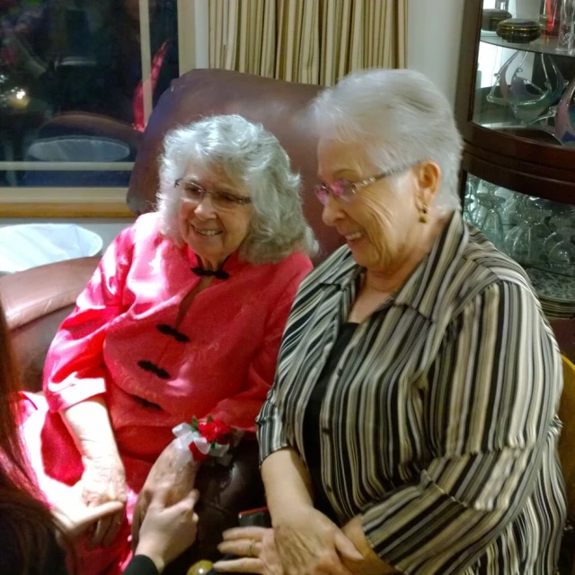 two women sitting next to each other in a living room