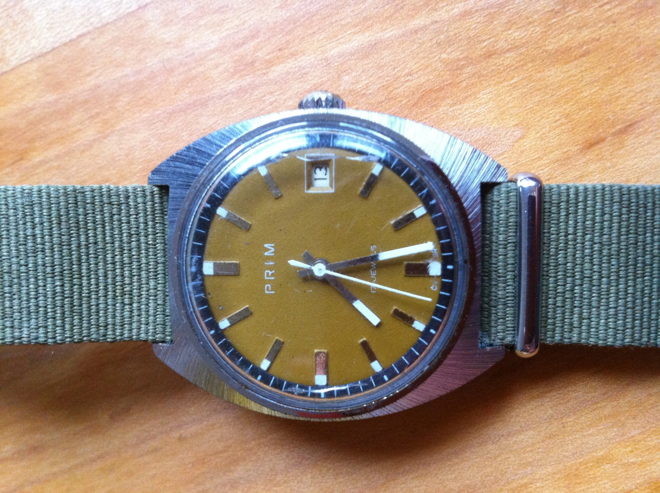 an old looking wrist watch with a yellow dial