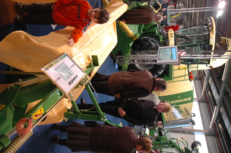 people standing around looking at machinery inside of a building