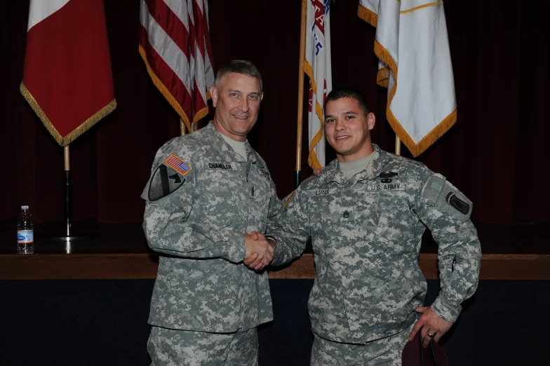 two soldiers are shaking hands at the end of an official ceremony