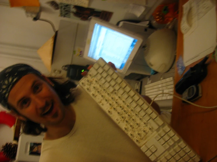 man at home posing with computer keyboard in foreground