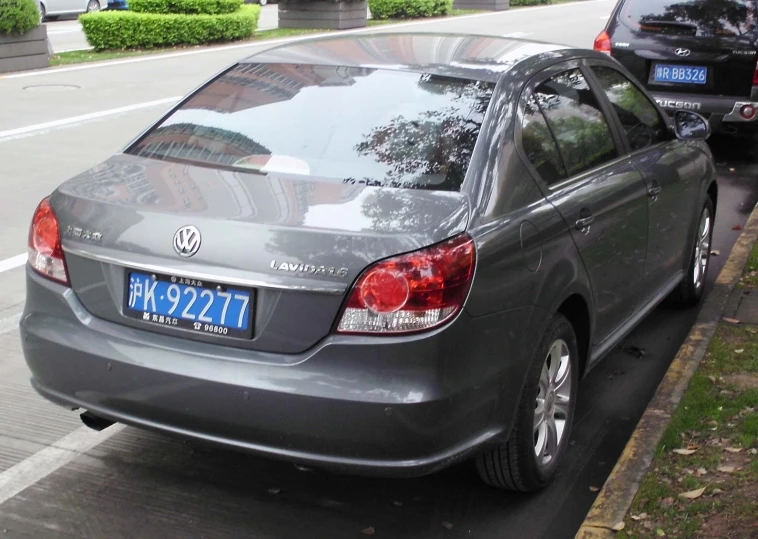 the back end of a silver car parked on the street