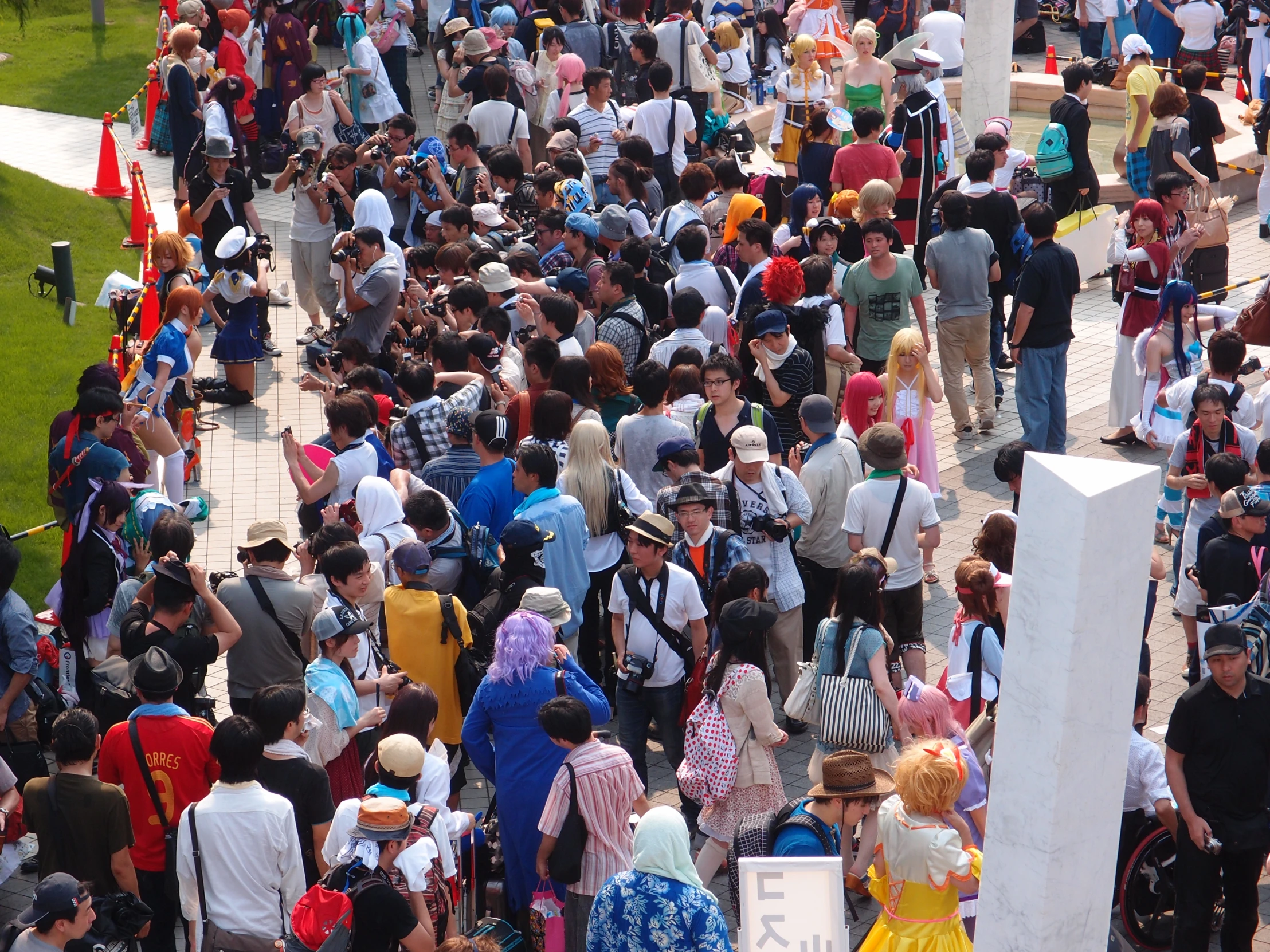 a crowd of people outside near a large white stone statue