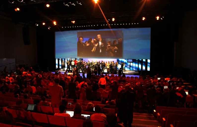 an image of people on stage performing at a business conference