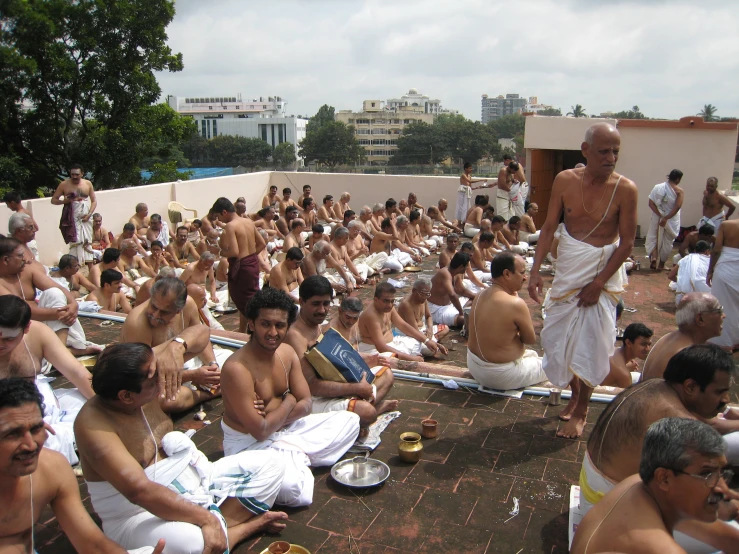 many men are gathered at the top of a roof to cool off