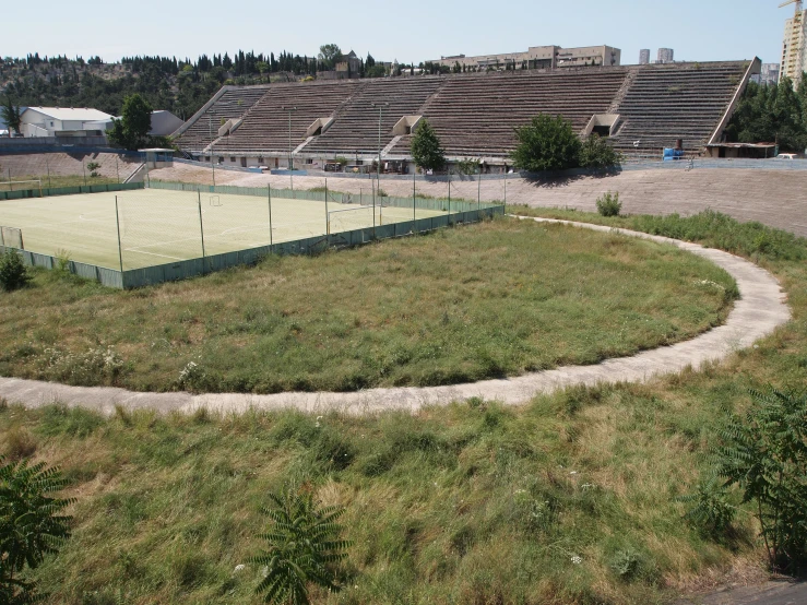 a green grass court sitting next to the road