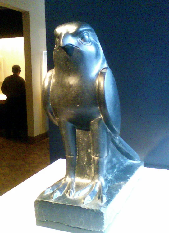 a bronze bird that is on display on a stand