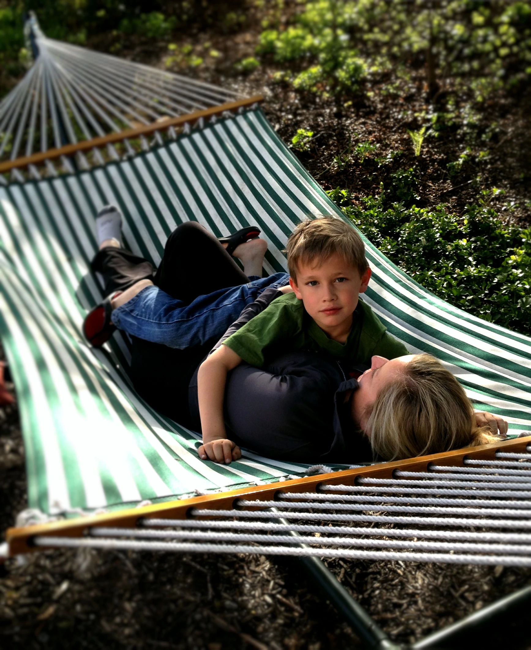 two people are laying in a hammock with their faces on each other