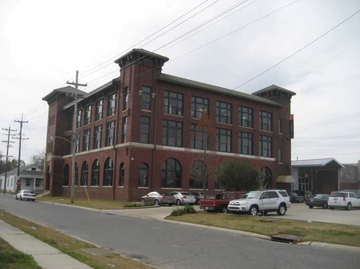 a large brick building with some trees and grass around it