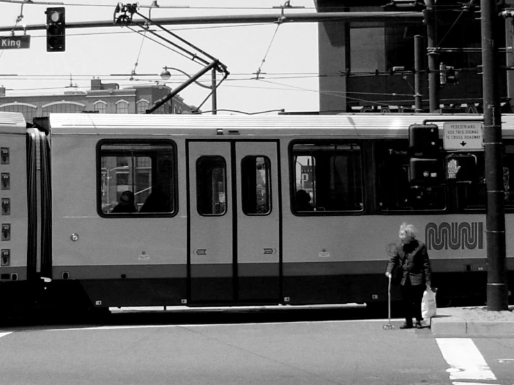 a woman that is standing by the side of a train