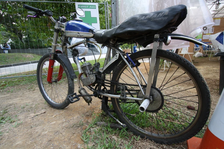 a bike with a black seat parked next to a street sign