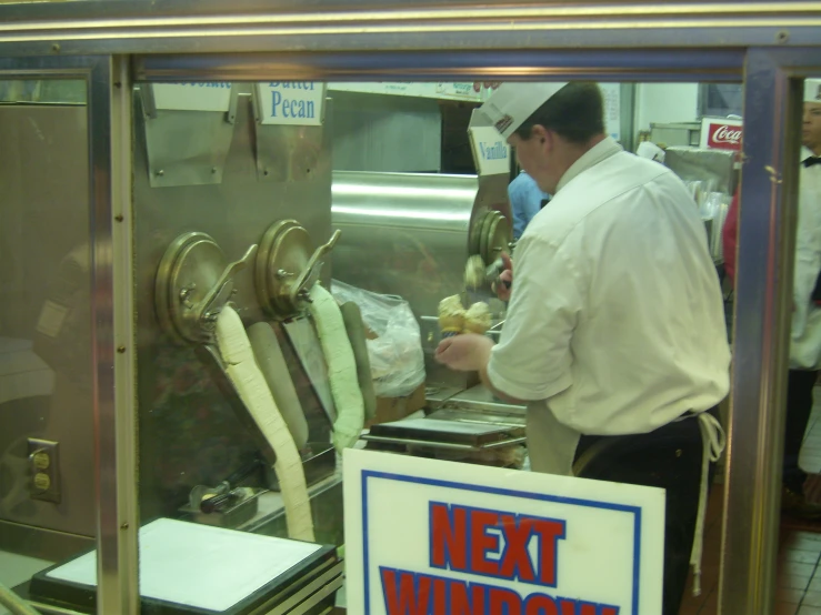 a person in a kitchen preparing food on a grill