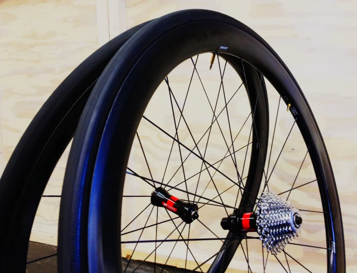 two bicycle wheels in front of a light wall