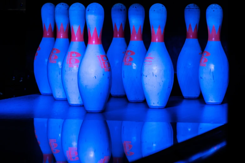 a row of blue bowling pins that are on a table