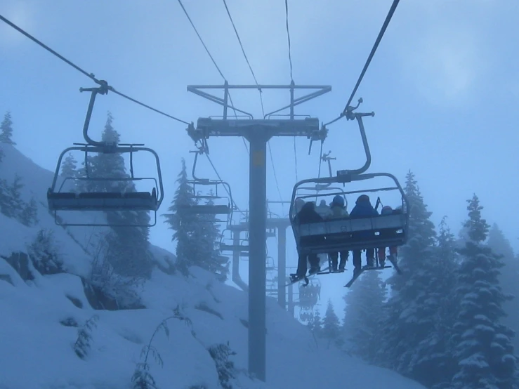 some people riding on a snow lift