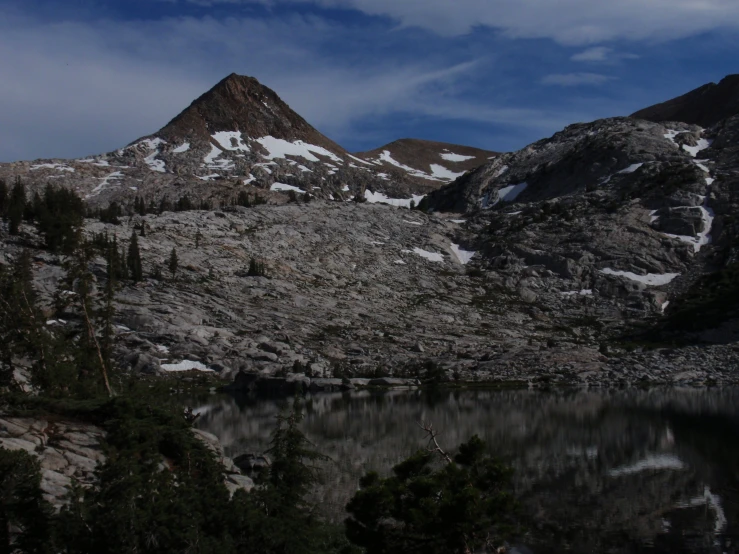 mountains are covered in snow with trees next to it