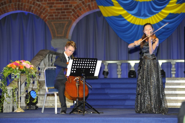 a woman in an elegant dress plays violin