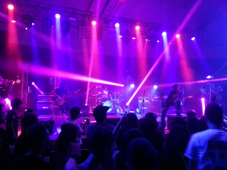 a band playing on a stage with colorful lights