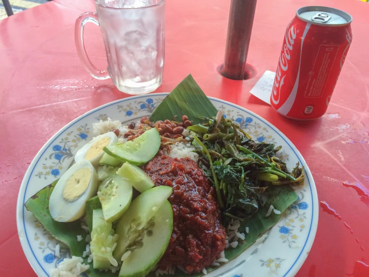 a plate of food is on the table near a soda