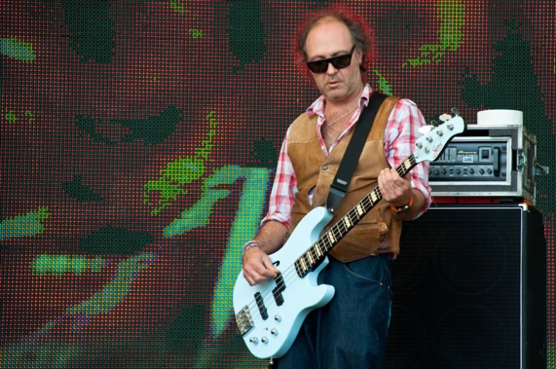 a man in sunglasses standing near an amp