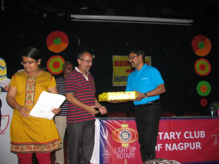 a person standing behind a table holding up a plaque