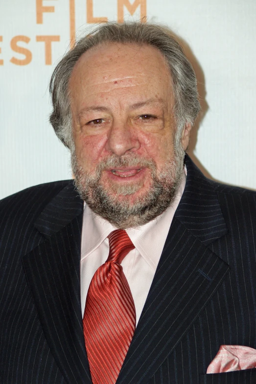 an older man with beard, wearing a red tie