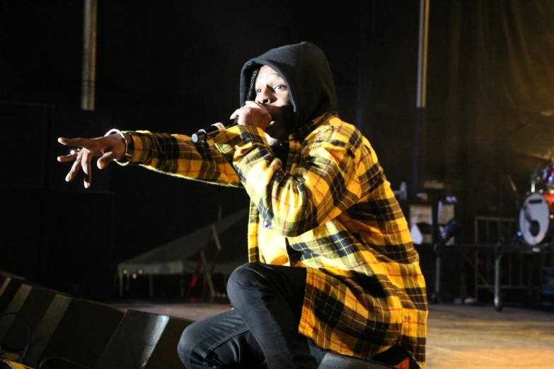 a man in a yellow jacket performing on stage