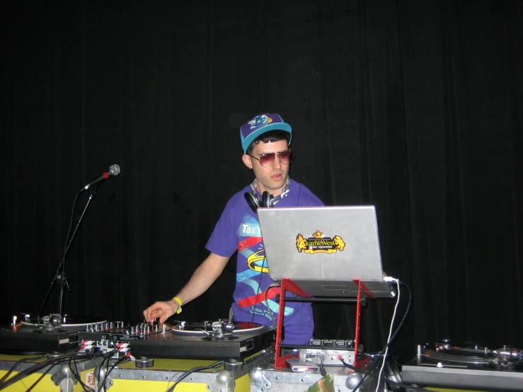 a young man that is standing in front of a laptop